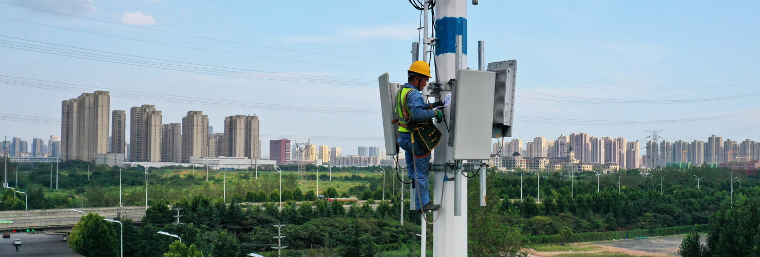 An employee of China Mobile Communications Group checks a 5G base station tower