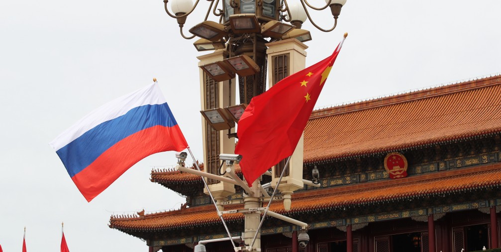 Chinese and Russian national flags flutter on a lamppost in front of the Tian'anmen Rostrum