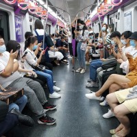 People on their phones in a Beijing subway