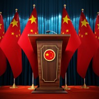 Group of Chinese flags standing next to lectern in the conference hall. 3D illustration. 