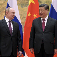 Chinese President Xi Jinping, right, and Russian President Vladimir Putin talk to each other during their meeting in Beijing, China, Friday, Feb. 4, 2022. 